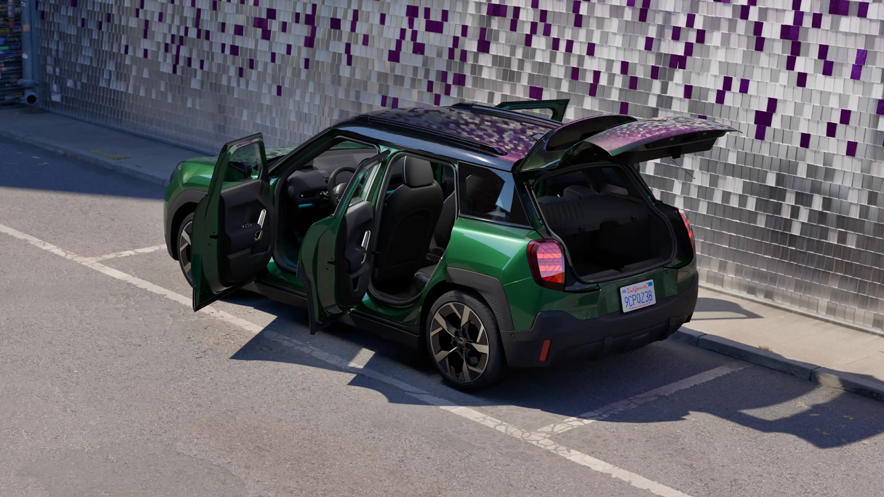 Заден страничен изглед на паркирано напълно електрическо MINI Aceman в цвят British Racing Green с отворени всички врати и цветна стена на заден план