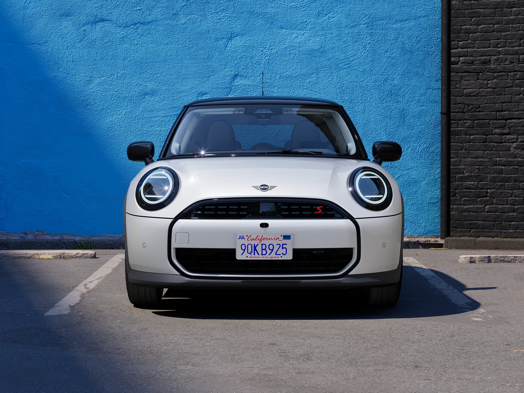 Изглед отпред на паркиращо MINI Cooper в цвят Nanuq White с черен покрив.