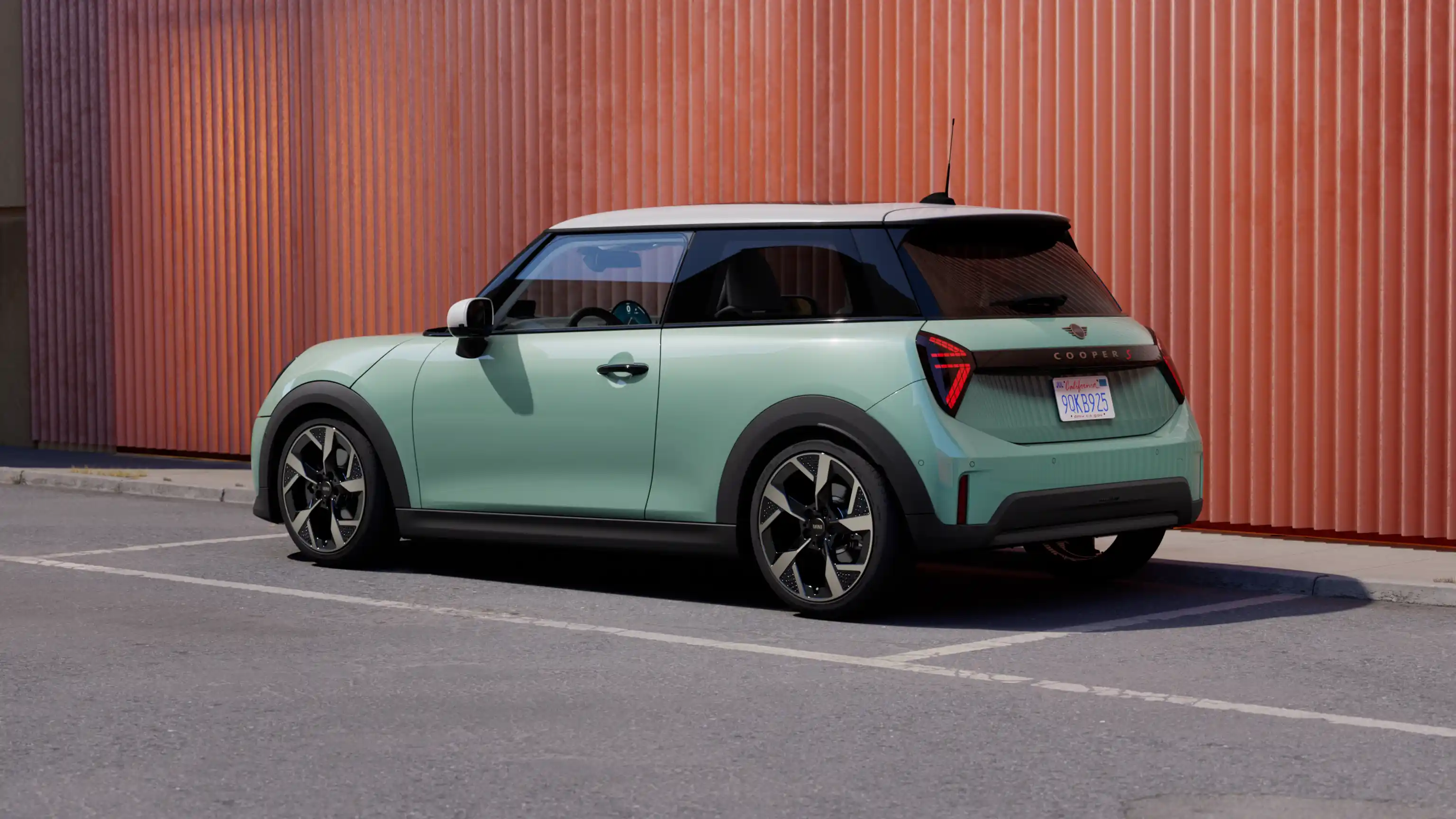 Изглед отзад на паркиращо MINI Cooper в цвят Ocean Wave Green с бял покрив