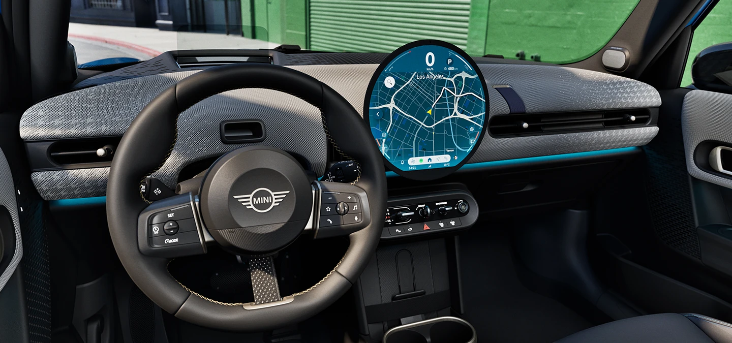 Вътрешен изглед на MINI Cooper 5 врати с фокус върху волана, арматурното табло и MINI Interaction unit.