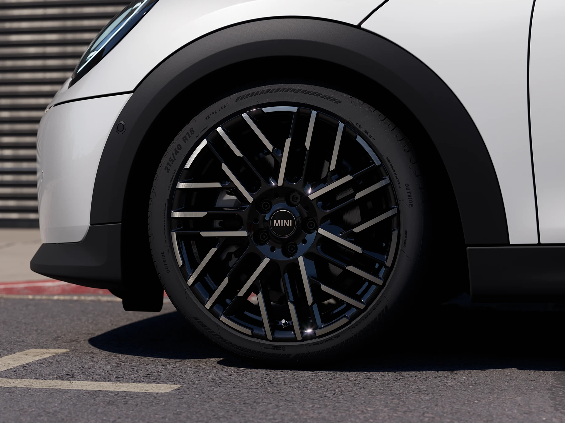 Близък кадър на MINI Cooper 5 врати в Nanuq White с двуцветни джанти Night Flash Spoke.