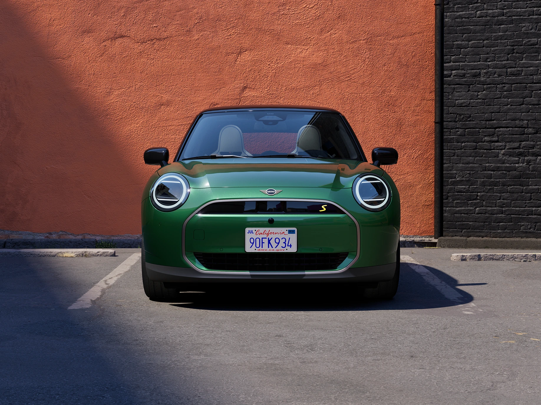 Изглед отпред на изцяло електрическо MINI Cooper в цвят British Racing Green с черен покрив.
