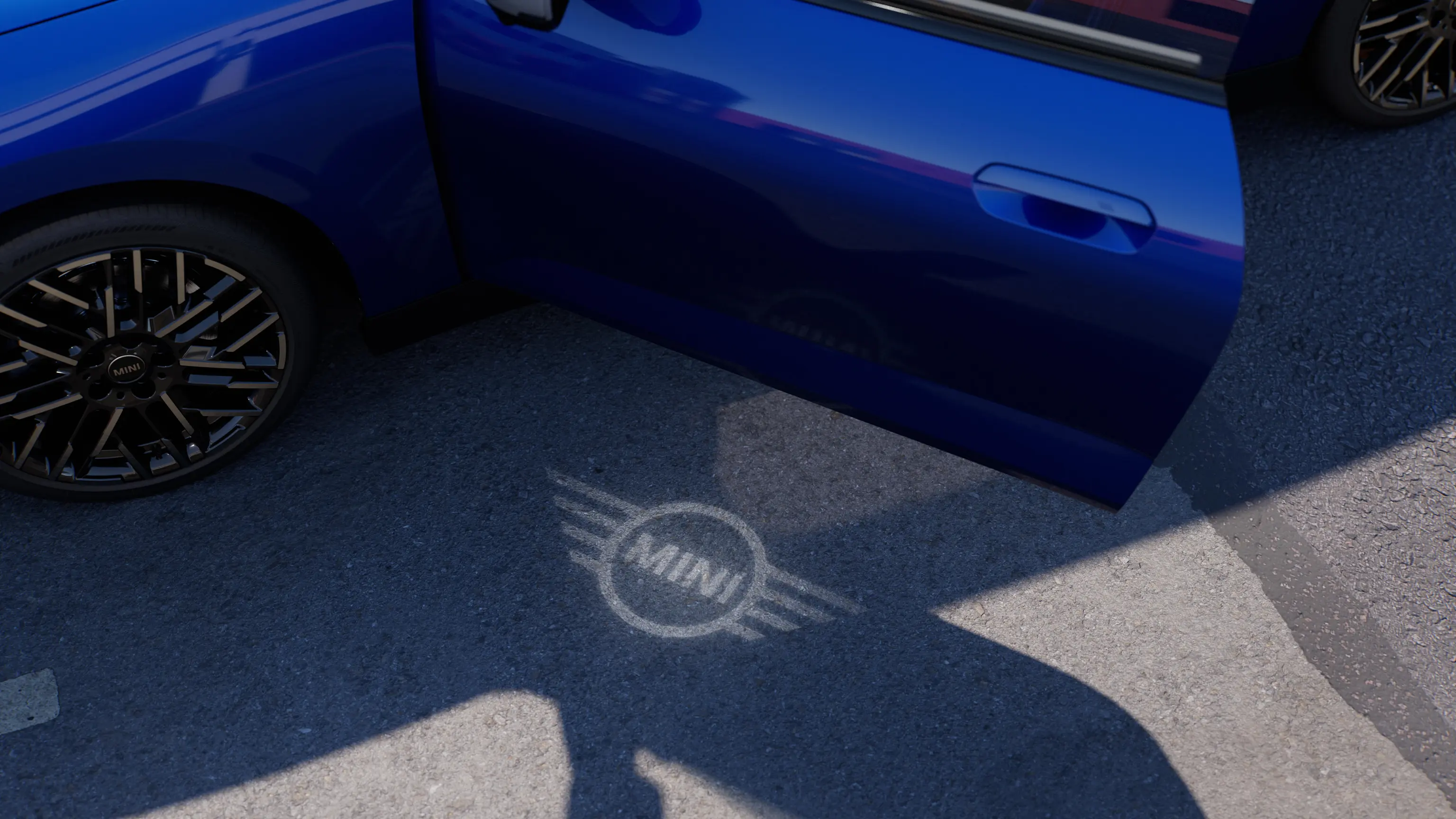 Външен изглед на напълно електрическото MINI Cooper с отворена врата и приветстваща светлина с логото на MINI на земята