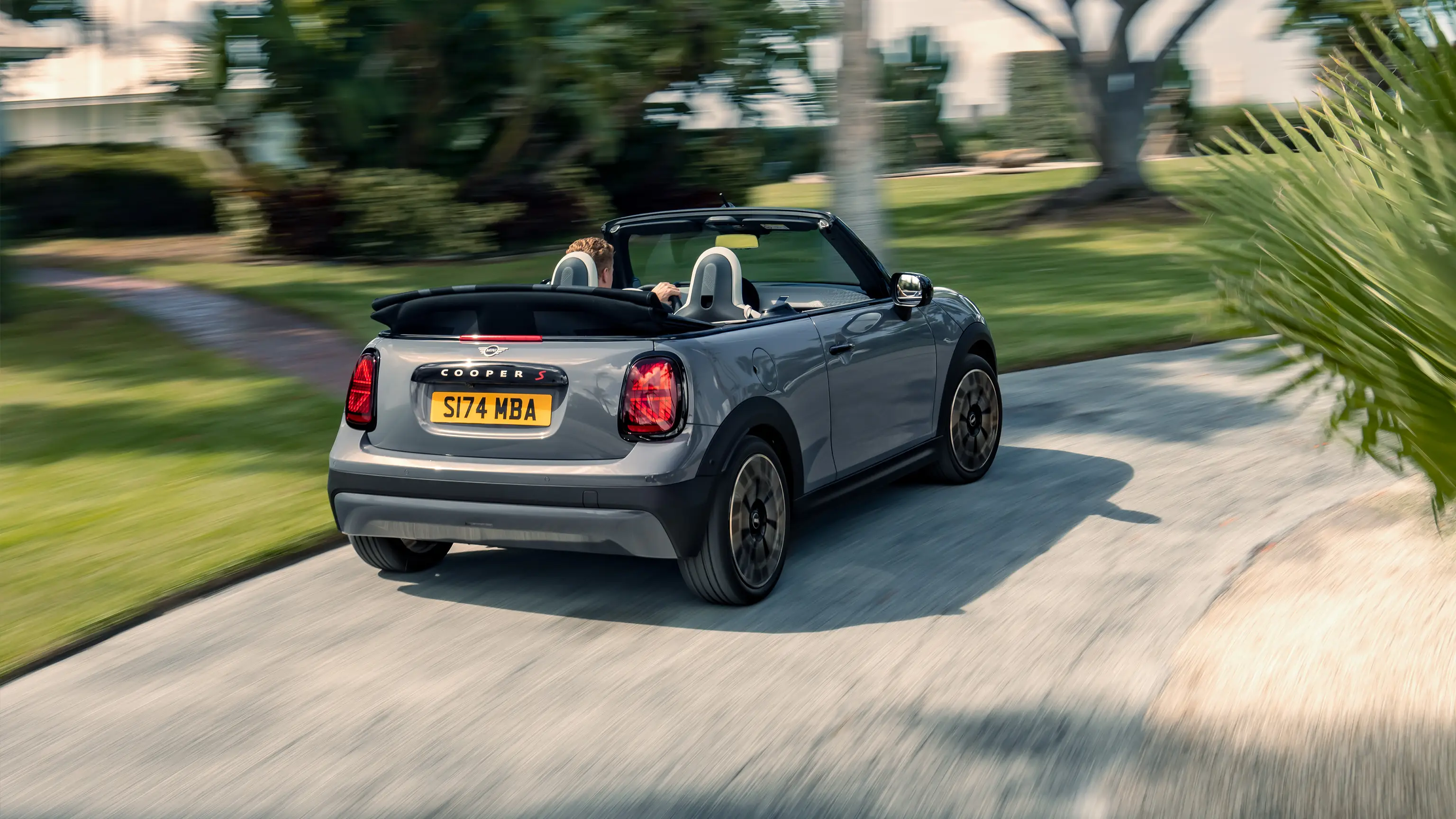 Изглед отзад на движещо се MINI Cooper Cabrio в Copper Grey