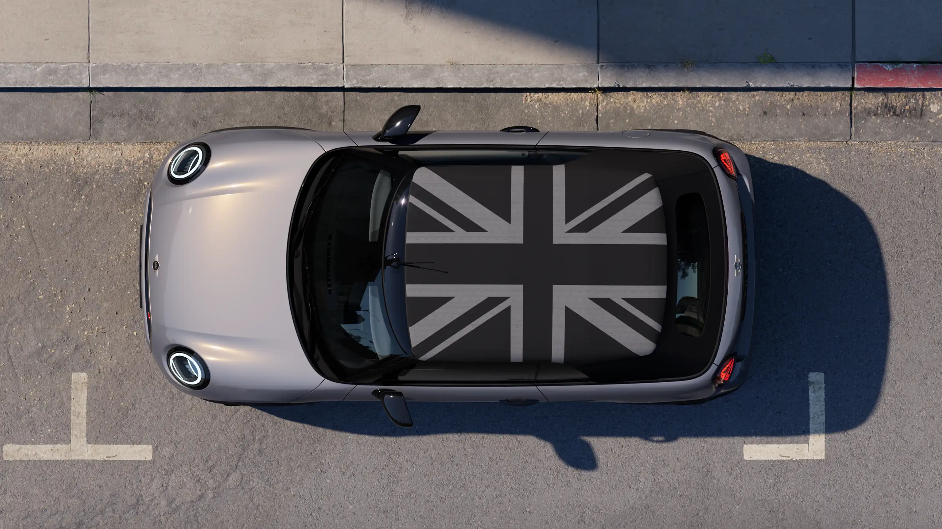 Изглед отгоре на MINI Cooper Cabrio в Copper Grey с паркиран на улицата MINI Yours Roof