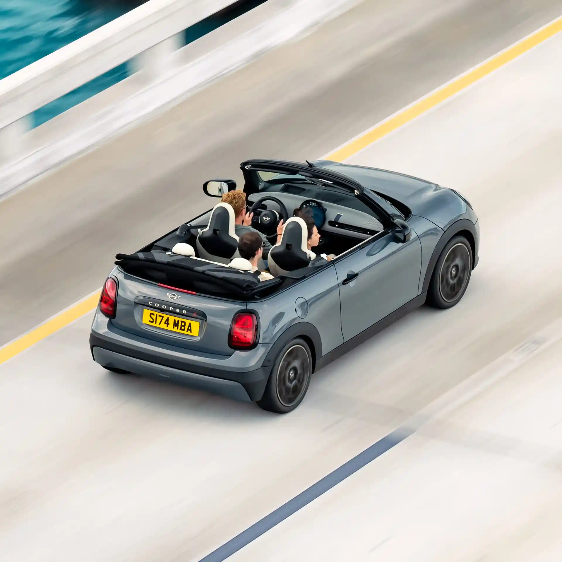 Изглед отгоре и отзад на движещо се MINI Cooper Cabrio по улица