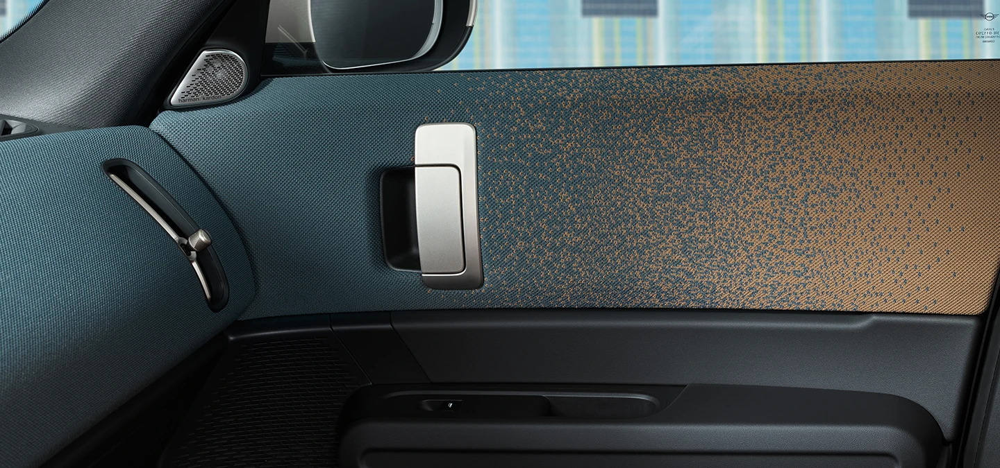 Близък план на интериорния дизайн на напълно електрическото MINI Countryman с фокус върху вратата и арматурното табло.