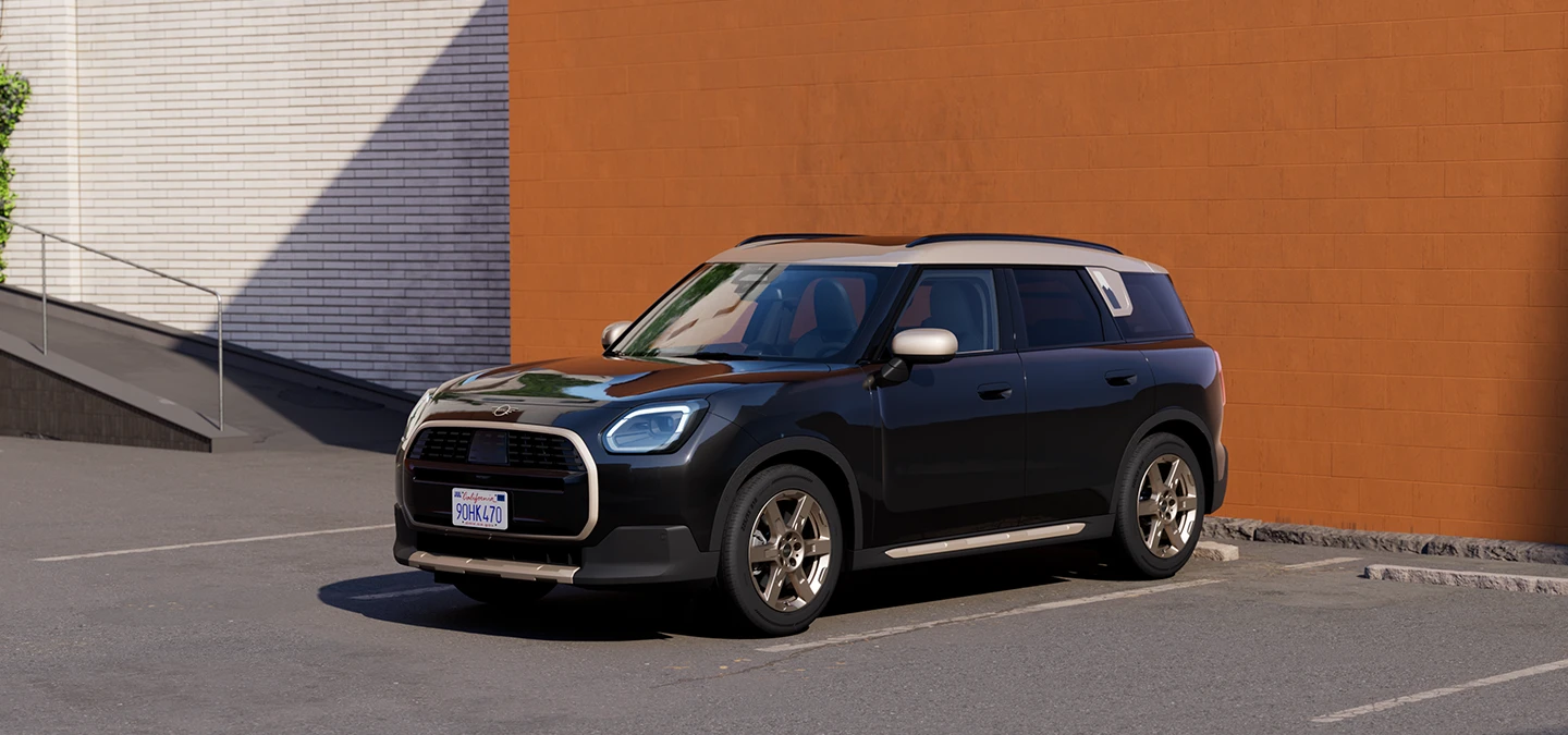 Изглед отпред и отстрани на MINI Countryman в цвят Midnight Black и покрив в цвят Vibrant Silver, което паркира.