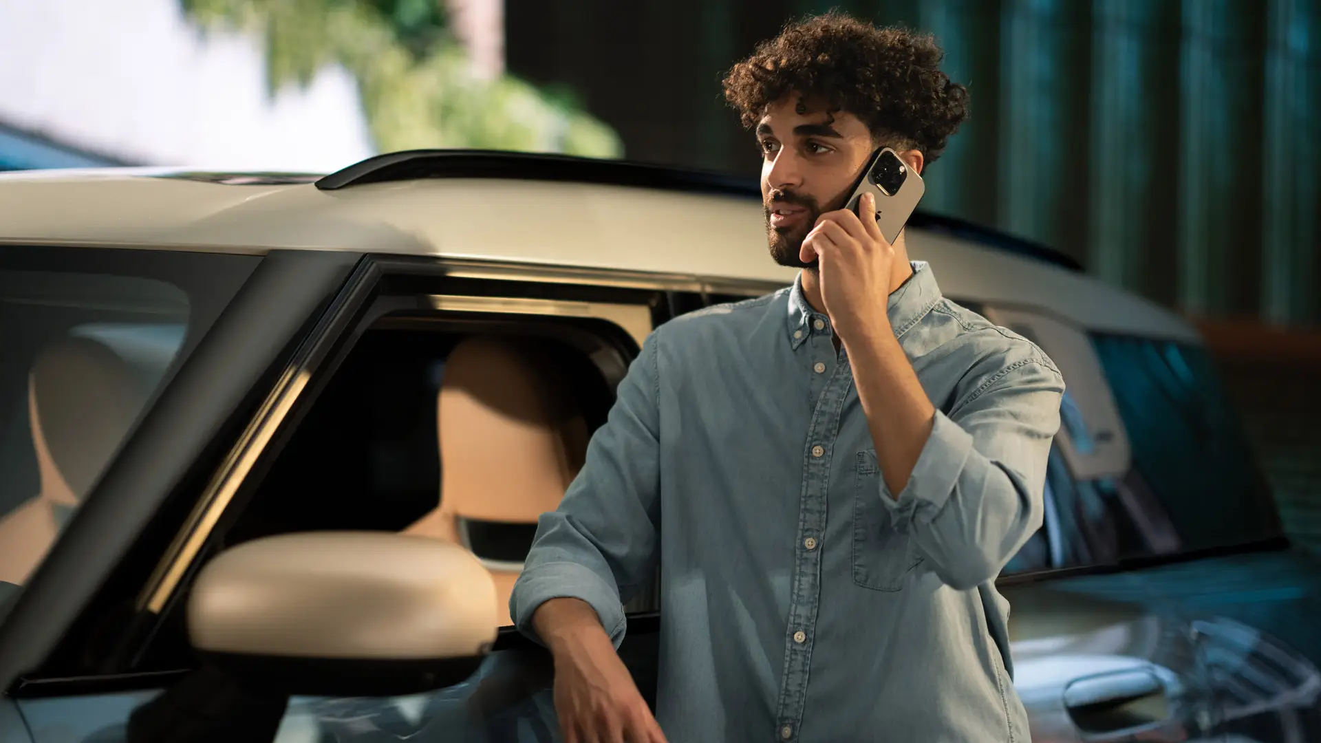 MINI Проактивна грижа – човек, стоящ отстрани на своето MINI, който разговаря по телефона с консултант от Сервизния център.