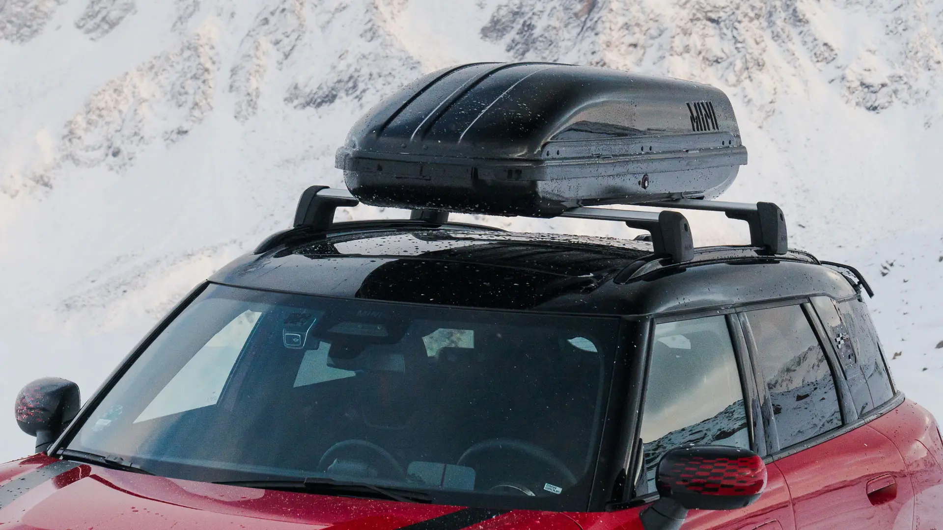 MINI Countryman в цвят Chili Red II с кутия за багаж на покрива MINI 320 в черно.