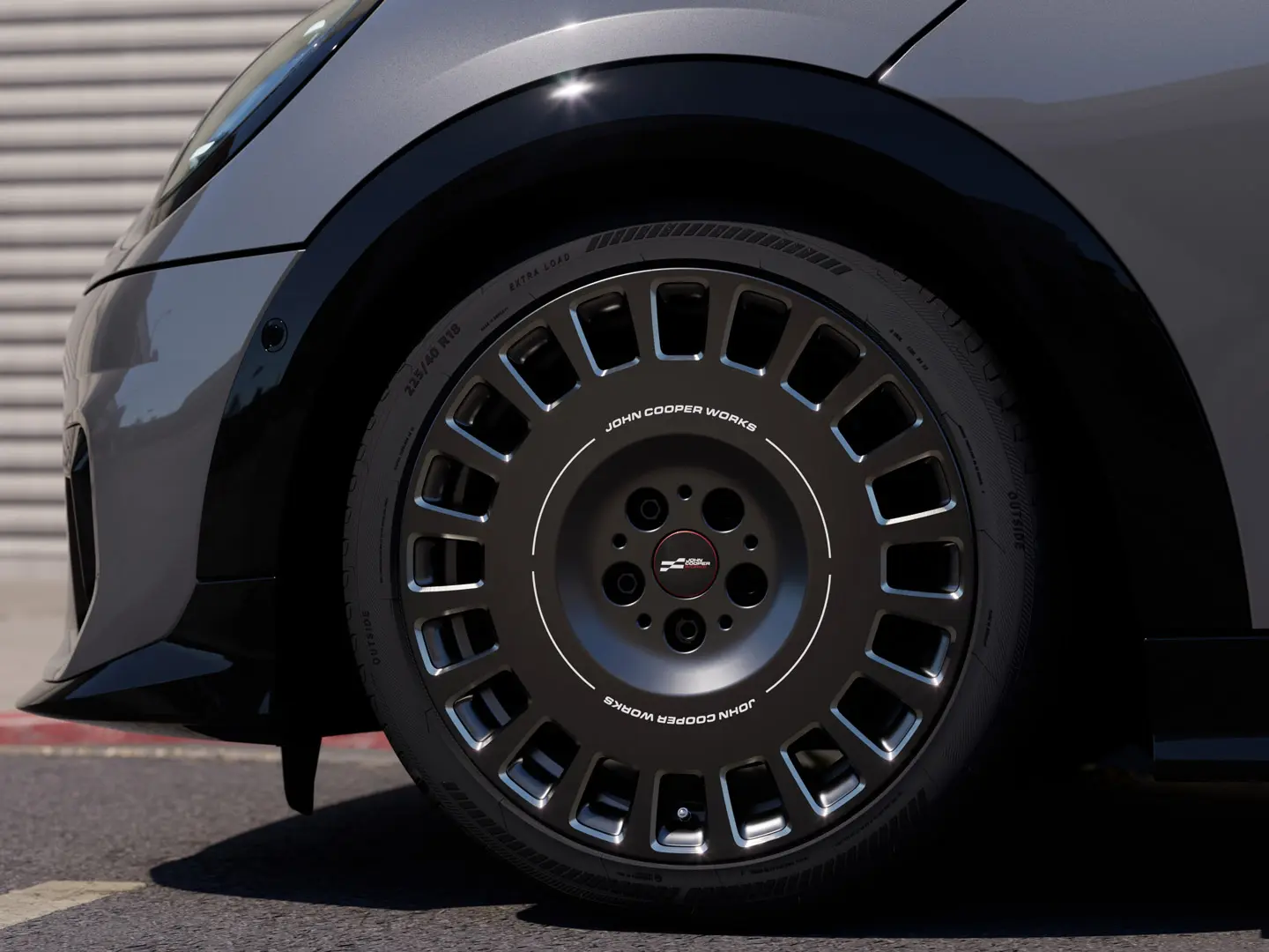 Близък план на диамантено шлифования детайл на 18-инчово колело MINI JCW Rallye Spoke 964 в цвят Frozen Midnight Grey. 