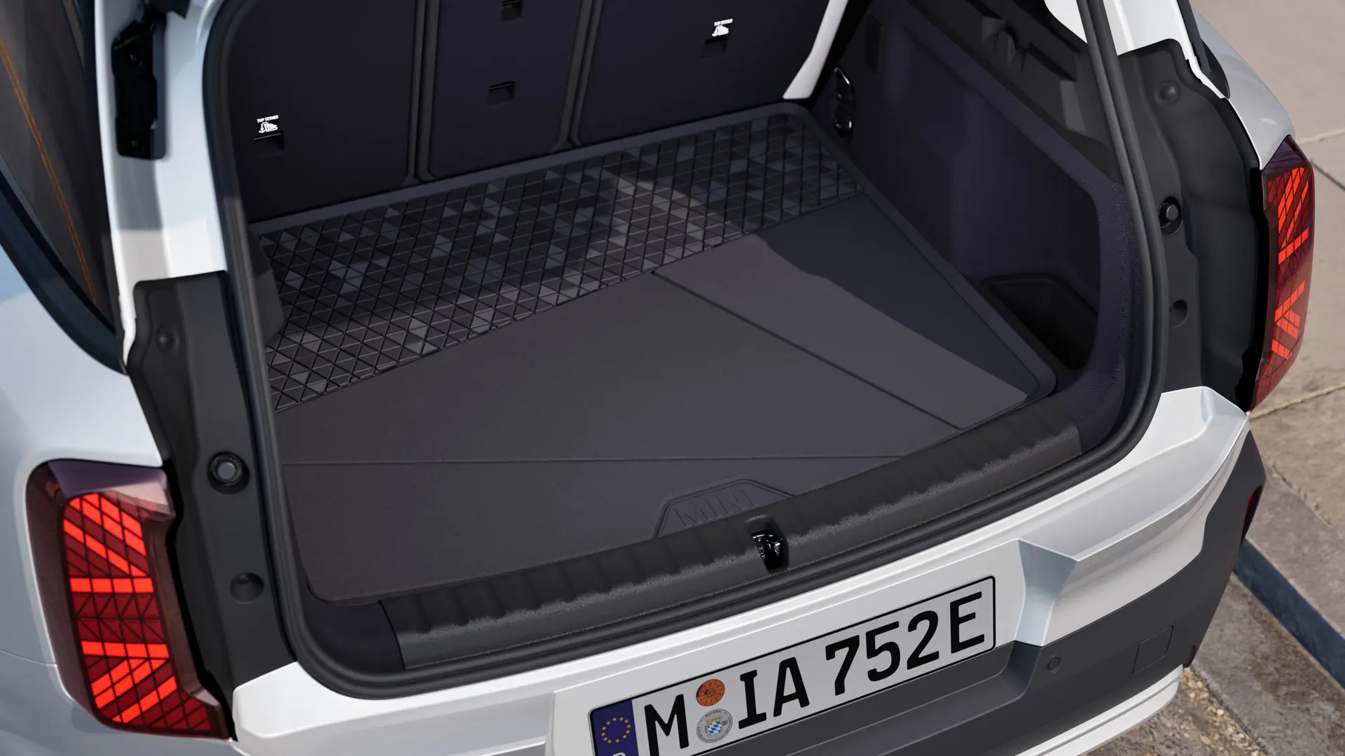 Черна, специално изработена по мярка постелка за багажника MINI с висок ръб от всички страни за защита от мръсотия и влага.