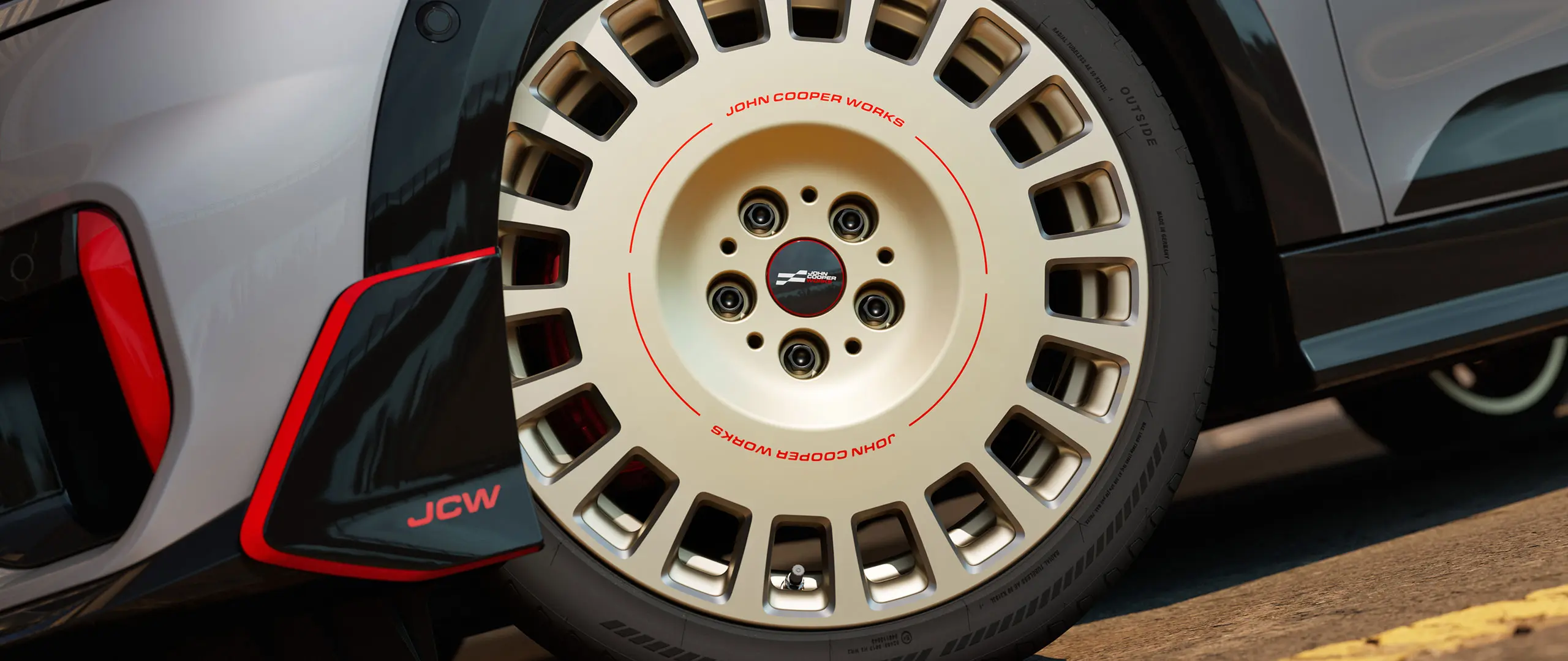 Близък кадър на детайлите на 18-инчово колело JCW Rallye Spoke 964 в двуцветно Vibrant Silver, с диамантено шлифоване и преден Winglet.