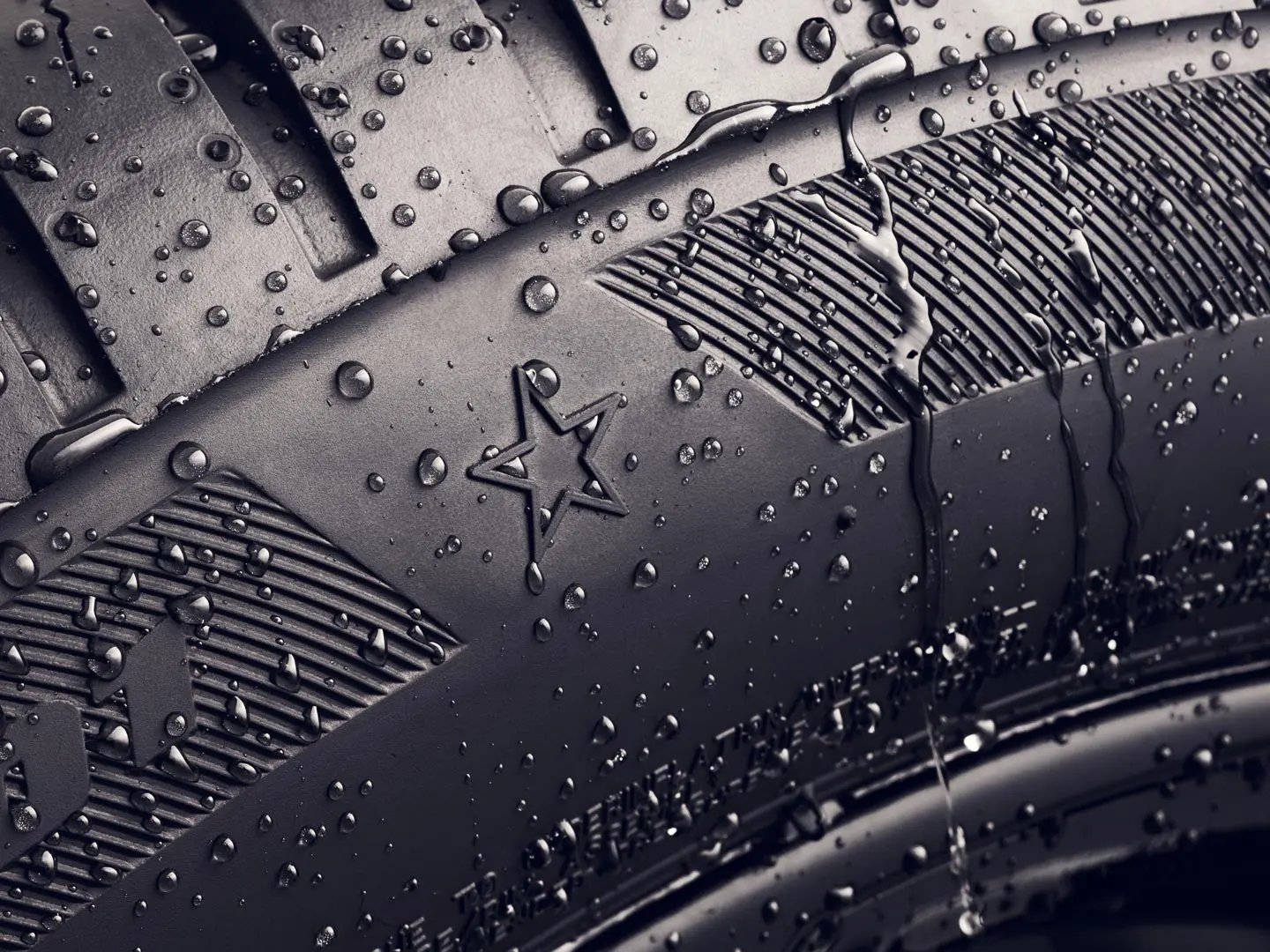 Близък кадър на странична стена на гумата, показваща символа на звездата, който показва, че тя е одобрена за оптимално представяне на превозните средства MINI. 