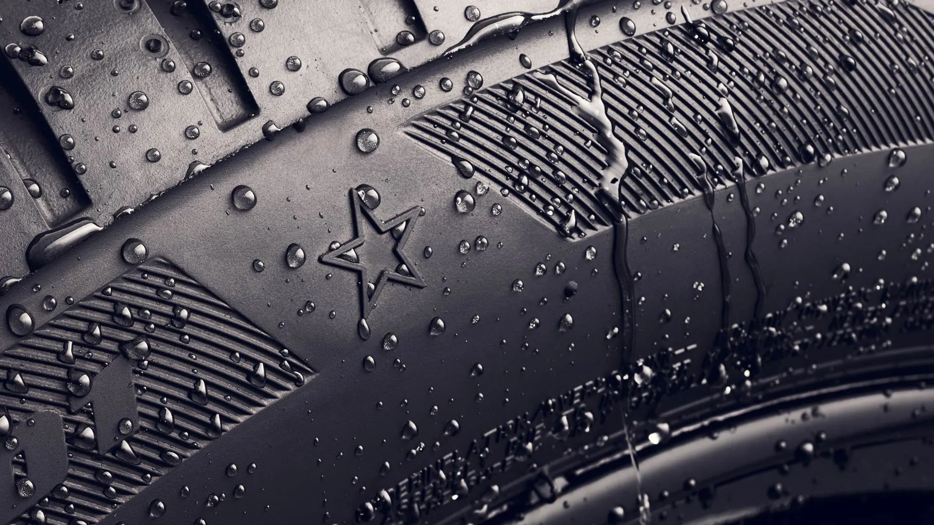 Близък кадър на странична стена на гумата, показваща символа на звездата, който показва, че тя е одобрена за оптимално представяне на превозните средства MINI. 