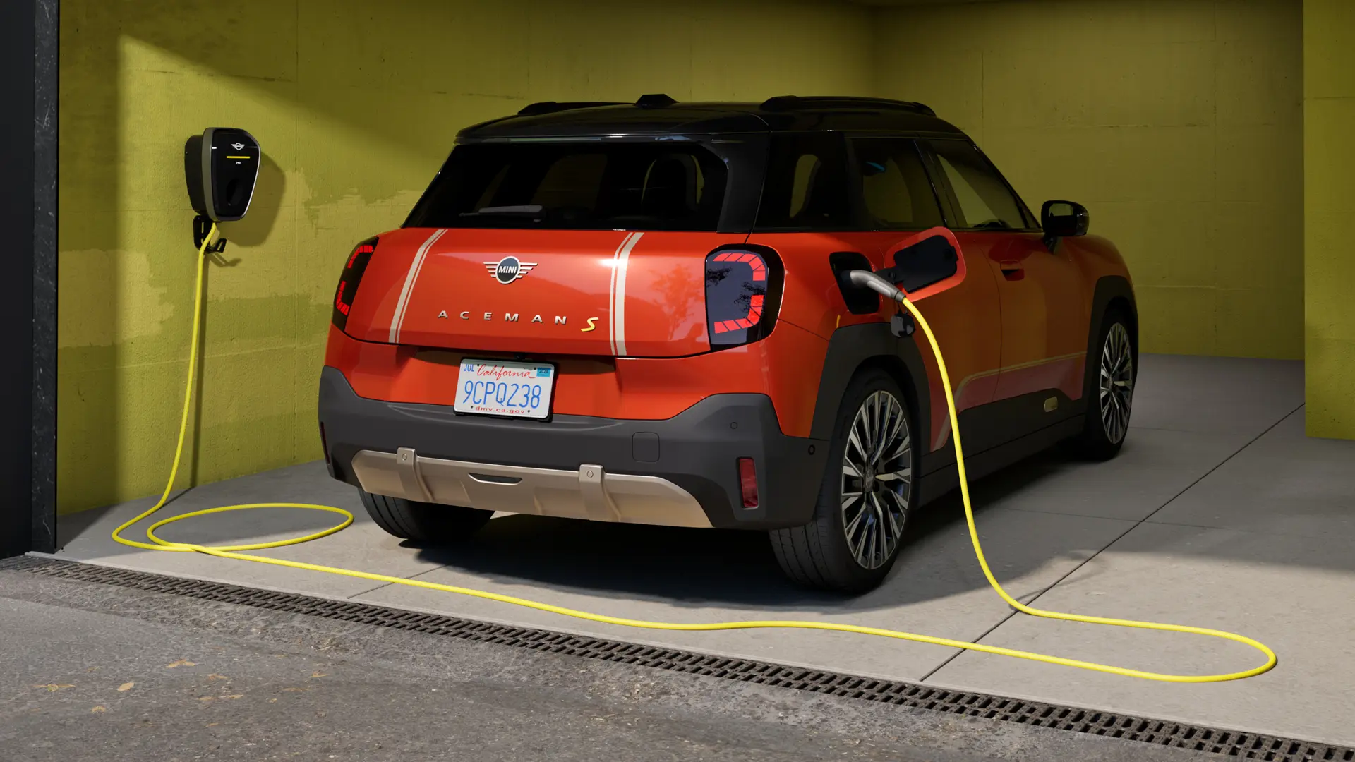 Изцяло електрически MINI Aceman S, който се зарежда с MINI Wallbox Plus, изглед отзад, паркиран в гараж.