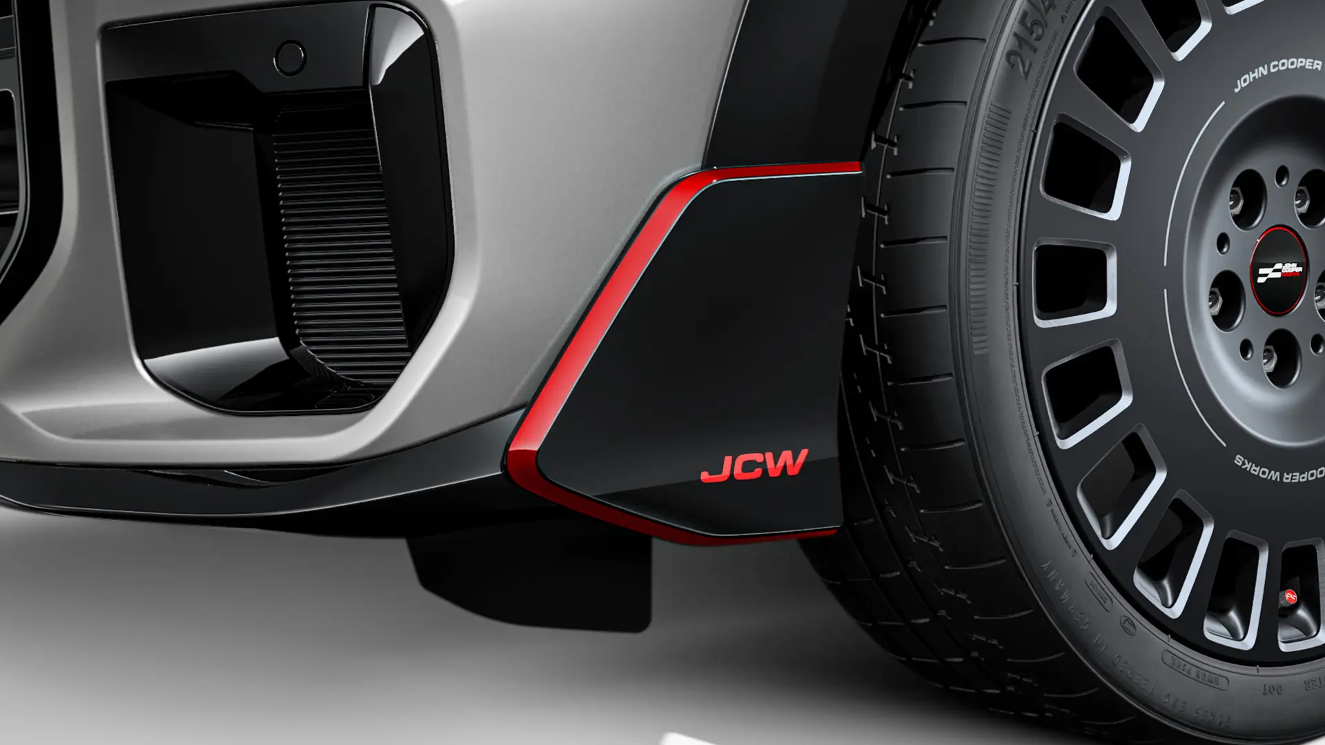 MINI John Cooper Works преден Winglet в черен гланц с червен надпис JCW и акцентни ленти.