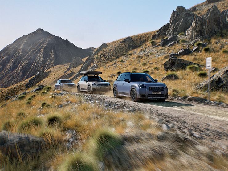 Изображение на няколко модела MINI Countryman Untamed Edition, движещи се по планински маршрут.