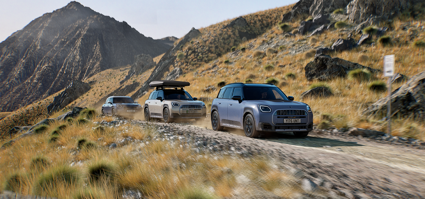 Изображение на няколко модела MINI Countryman Untamed Edition, движещи се по планински маршрут.