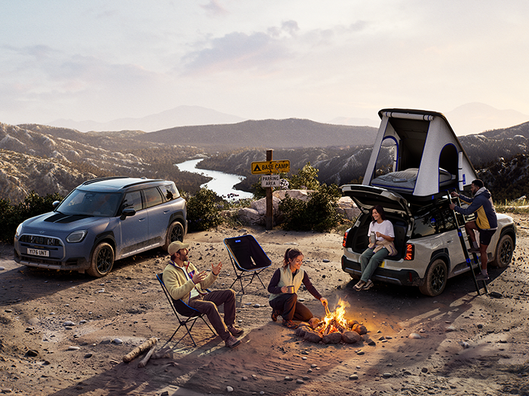 Снимка на две превозни средства MINI Countryman Untamed Edition на планина при залез слънце.
