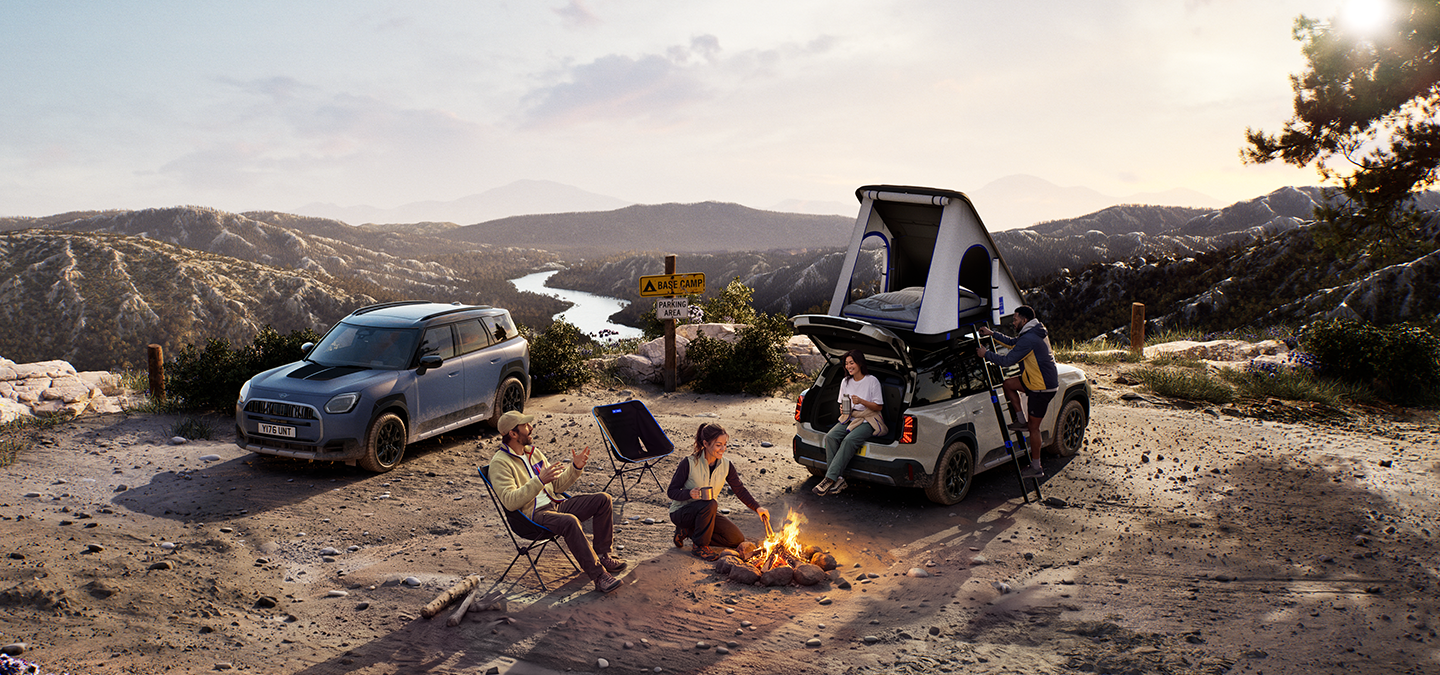 Снимка на две превозни средства MINI Countryman Untamed Edition на планина при залез слънце.